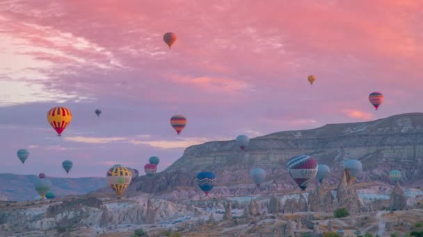 Färgglada varmluftsballonger flyger över bergslandskapet vid soluppgången Goreme, Kappadokien, Turkiet. Tidsåtgång 4K. — Stockvideo