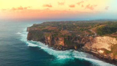 Günbatımında, Endonezya 'daki Bali Adası' ndaki Uluwatu Tapınağı 'nda büyük okyanus dalgaları ve kayaların hava manzarası.