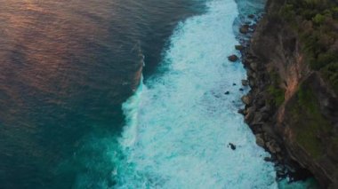 Endonezya 'daki Bali Adası' ndaki Uluwatu Tapınağı 'ndaki büyük okyanus dalgaları ve kayalara bakın.