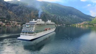 Cruise liner ship swimming at blue adriatic sea on mountains landscape port of Kator, Montenegro. KOTOR, MONTENEGRO - JULE 24, 2021