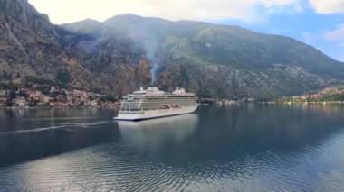 Cruise liner ship swimming at blue adriatic sea on mountains landscape port of Kator, Montenegro. KOTOR, MONTENEGRO - JULE 24, 2021
