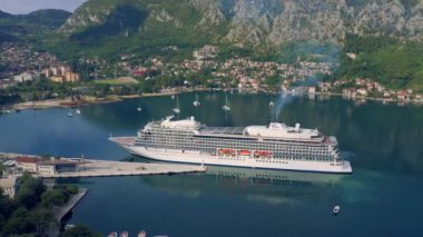 Cruise ship in the port of Kotor at mountains background, Montenegro. Aerial view 4K