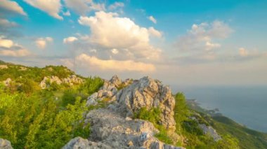 Günbatımının üzerinde kaya dağı uçurumu gökyüzü arka planı. Zaman Dilimi 4K