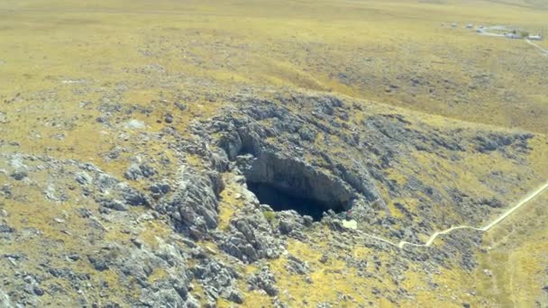 Провал в пещере Ак Мечет в Шымкенте, Казахстан. Вид с воздуха 4K. — стоковое видео
