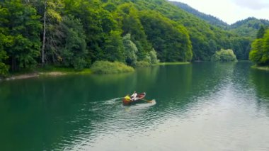 Karadağ 'daki Biogradsko Gölü' nde bir teknede genç bir çift. Hava görüntüsü 4K.