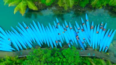 Maasin Nehri 'nde, yemyeşil palmiye ağaçları ve yeşil yapraklar, Siargao, Filipinler ile çevrili sayısız mavi kano manzarası var..