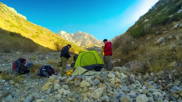 Os alpinistas montam uma tenda nas montanhas — Vídeo de Stock