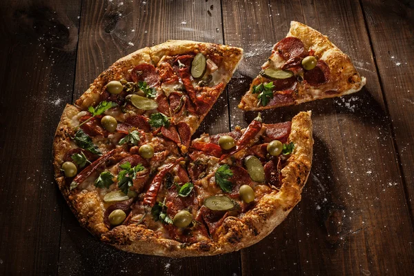 Läcker italiensk pizza med slice serveras på träbord — Stockfoto