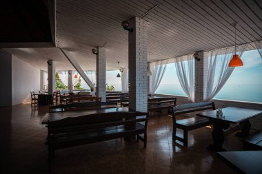 Abhazya 'da deniz kıyısında ahşap masaları olan güzel bir restoranın içi.