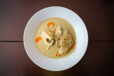 Abhaz lezzetli tavuk ve baharat tabağı beyaz bir tabakta ahşap bir masada.