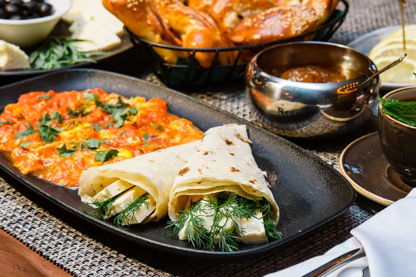 Peynirli, otlu ve sebzeli bir restoranda iştah açıcı bir kahvaltı.