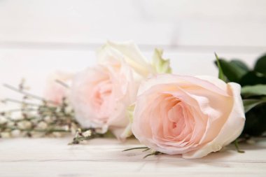 Ahşap masada pembe güllerin yakın çekimi