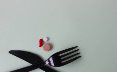 Siyah tabletli siyah çatal bıçak takımı. Arka planda çatal ve tabletli bıçak.