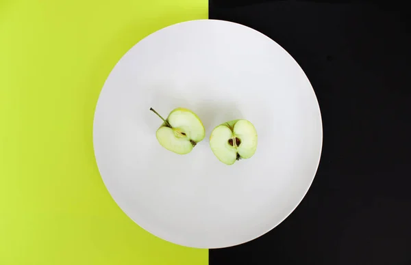 Fatias de maçã em uma placa branca em um fundo verde-preto, visão superior, espaço para texto — Fotografia de Stock