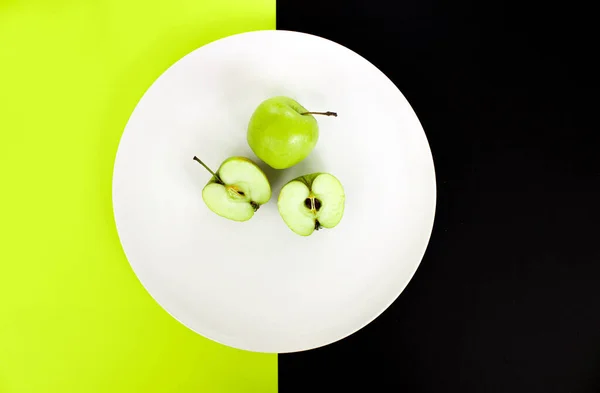 Fatias de maçã em uma placa branca em um fundo verde-preto, visão superior, espaço para texto — Fotografia de Stock