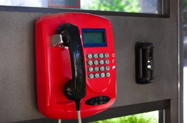 Telefon kulübesi, yakın plan. Sokakta kırmızı ankesörlü telefon.