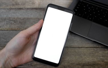İş yerindeki cep telefonunun el ele tutuşma görüntüsü. Telefon Ahşap Masada Boş Ekran, Model Telefon.