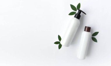 Beyaz arka planda beyaz boş kozmetik şişelerinin bir kopyası. Boşluğu kopyala, Top View.