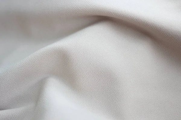 Bej kumaşın ya da bej renkli kumaşın yakın çekim dokusu. Bej arkaplanının kumaş dokusu. Buruşmuş bej kumaş — Stok fotoğraf
