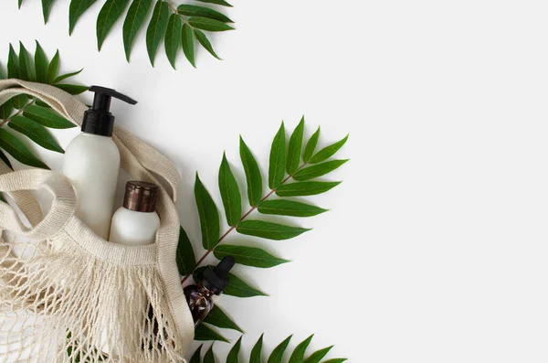 Beyaz, boş, tüp içinde, beyaz arka planda, yapraklı bir eco alışveriş torbası. Doğal Organik Spa Kozmetik Güzellik Konsepti