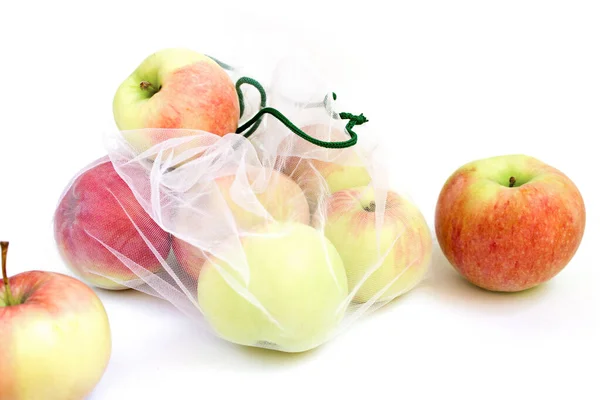 Beyaz arkaplanda yeniden kullanılabilir bir çantadaki elmalar — Stok fotoğraf