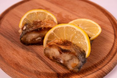 Tahta tepside limon dilimli ızgara balık.