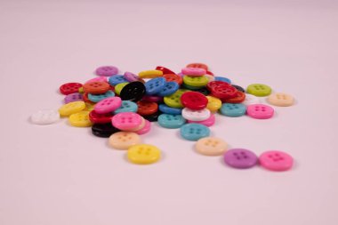 Beyaz arkaplanda parlak ve farklı renkli düğmeler