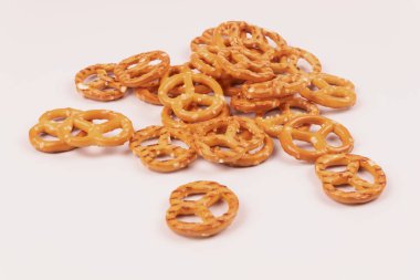 Beyaz arka planda bir sürü tuzlu kraker var.