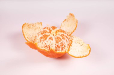 Çerçevenin ortasında kabukları olan yarı soyulmuş bir mandalina.