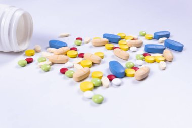 Kavanoza saçılmış renkli hapların yan görüntüsü