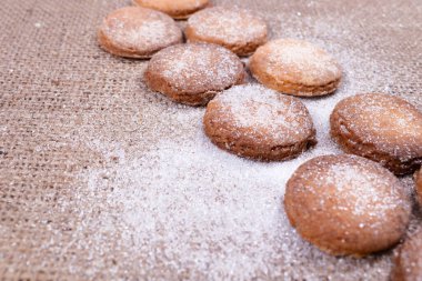 İki sıra halinde katlanmış, gri bir halıya serpiştirilmiş bisküvilerin yakın çekim görüntüsü.