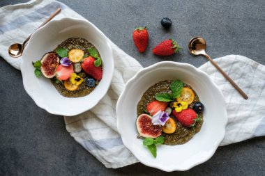 Çilekli chia tohumu ve yaban mersinli incir ve kablı çiçek, yakın görüş, sağlıklı kahvaltı konsepti 