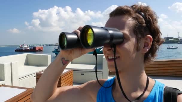O homem no barco olhando através de binóculos — Vídeo de Stock