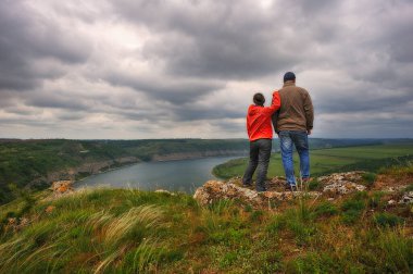 Kayalıklarda bir çift turist. Bir adam ve bir kadın resimli nehir kanyonuna bakıyorlar.