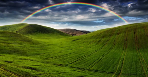 Scenic View Rainbow Green Field Dramatic Gray Sky Picturesque Hilly — Stock Photo, Image