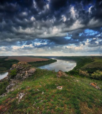 Güneşin doğuşuyla güzel bir bahar manzarası. Resimli bir kanyonun üzerinde bulutlar