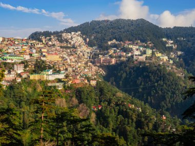 Güzel şehrin hava manzarası dağlara kaçıyor ve arka planda bulutlu gökyüzü var.
