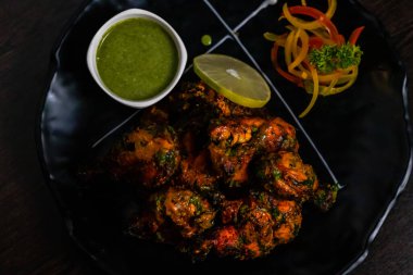 Yeşil baharatlı soslu leziz kızarmış tavuk ve garnitürlü limon manzarası.