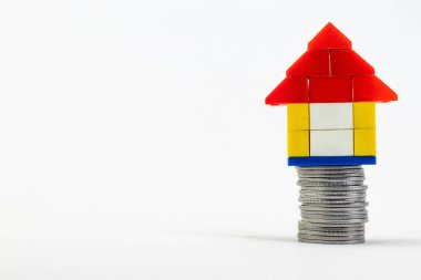 Ev kredisi konseptinde fotokopi alanı olan madeni paraların üzerindeki oyuncak evin yakın plan çekimi.