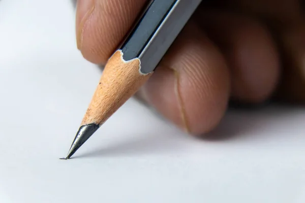 Close up shot of fingers holding a pencil and ready to write on the white paper -Start concept