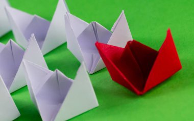 Liderlik konsepti için kırmızı olanı takip eden beyaz kağıt teknelerin yüksek açılı yakın çekimi