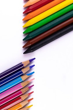 Portre kipi üst üste renkli kalemlerin ve pastel boya kalemlerinin birbirine bakan noktalarının yakın çekimi - eğlenceli öğrenme ve çizim kavramı