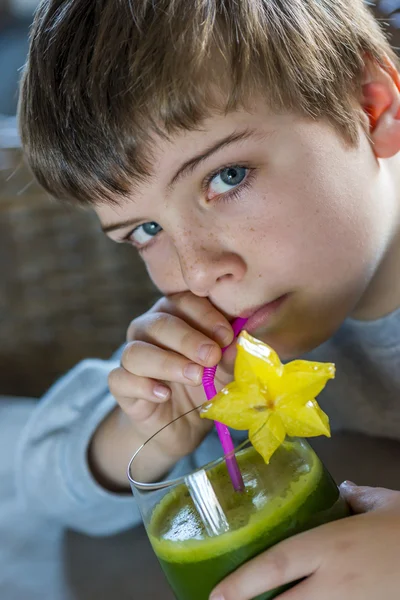 Мальчик пьет зеленый смузи — стоковое фото