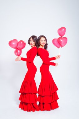 Balonlu uzun kırmızı giysili iki genç güzel kadın
