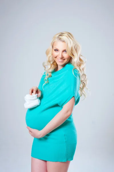 Young beautiful pregnant woman in a green sweater — Stock Photo, Image