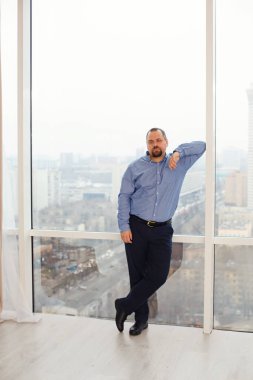 Kendinden emin genç bir adam kameraya bakar. Mutlu yakışıklı adam pencerede duruyor, geleceği düşünüyor. Gülümseyen rastgele bir insanın yüzünün yakın plan resmini düşünün..