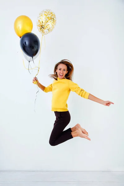 Una Mujer Joven Suéter Amarillo Salta Sostiene Montón Globos Oro — Foto de Stock