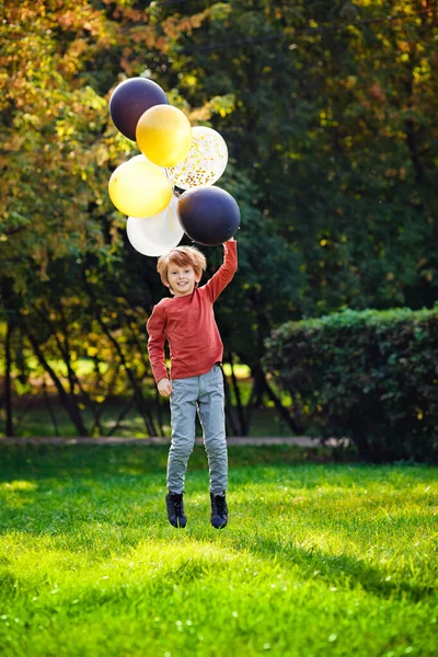 Joven Chico Pelirrojo Jugando Con Montón Globos Negros Blancos Amarillos —  Fotos de Stock