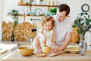 Beyaz bir baba ve kızı, komik bir baba ve kız mutfakta sarılıp yemek yapıyorlar. Parlak bir mutfak, yaşam tarzı ve babalar günü, bekar ebeveynler günü.