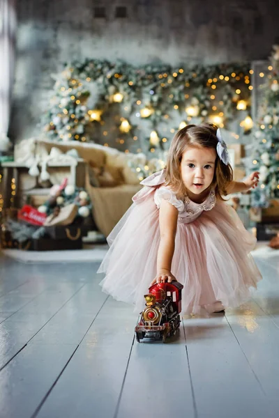 Ein Kleines Mädchen Einem Eleganten Kleid Spielt Mit Einer Lokomotive — Stockfoto